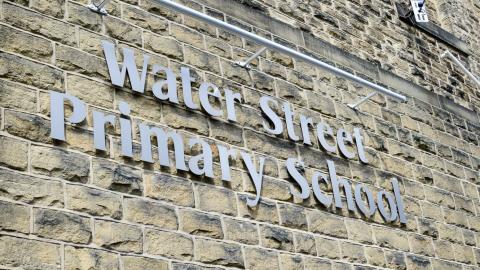 Large sign saying water street primary school on the side of the school building